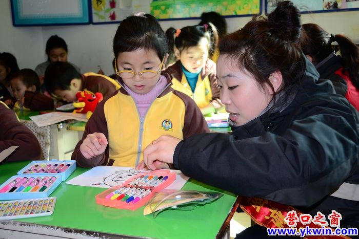 青年自愿者細心教導(dǎo)小朋友們作畫